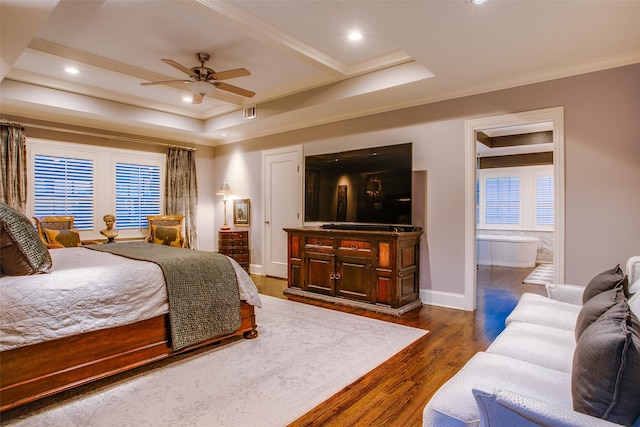 bedroom with dark wood-type flooring, a tray ceiling, and crown molding