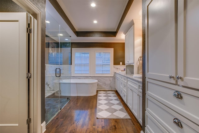 bathroom featuring a wainscoted wall, vanity, ornamental molding, a soaking tub, and a shower stall