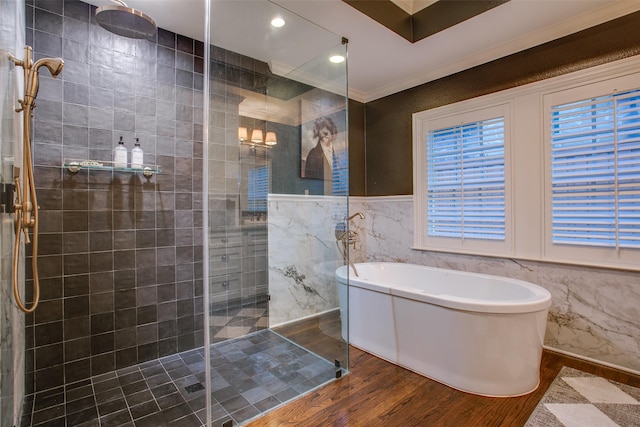 bathroom with wood finished floors, a soaking tub, crown molding, and a walk in shower