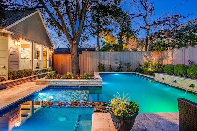 view of pool with a fenced backyard and a pool with connected hot tub