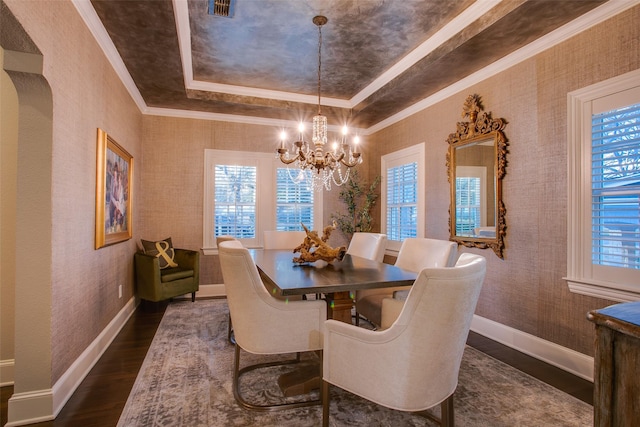 dining room featuring dark wood-style floors, a tray ceiling, a healthy amount of sunlight, and wallpapered walls