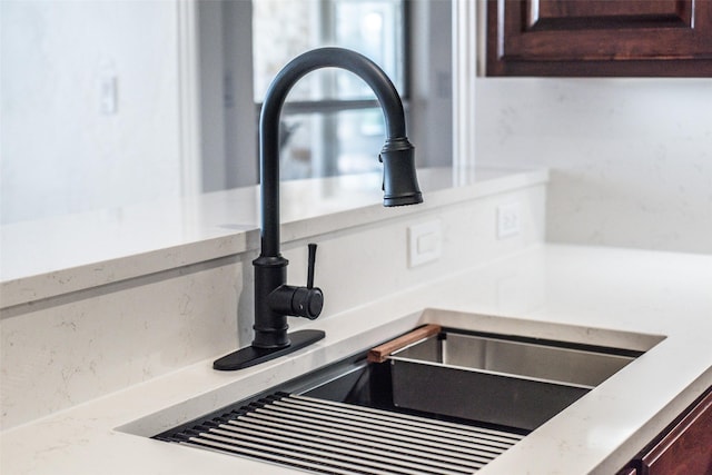 room details with a sink, dark brown cabinetry, and light countertops