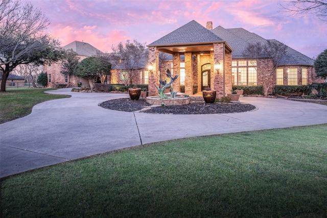 exterior space featuring a yard and curved driveway