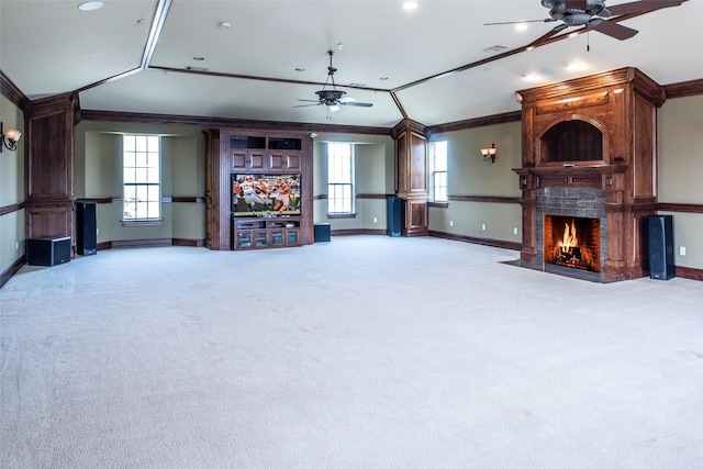 unfurnished living room with a large fireplace, ceiling fan, light colored carpet, lofted ceiling, and ornamental molding