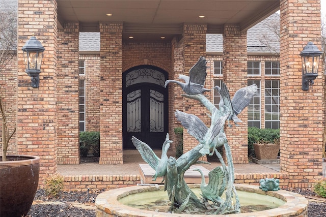 property entrance with brick siding and a shingled roof