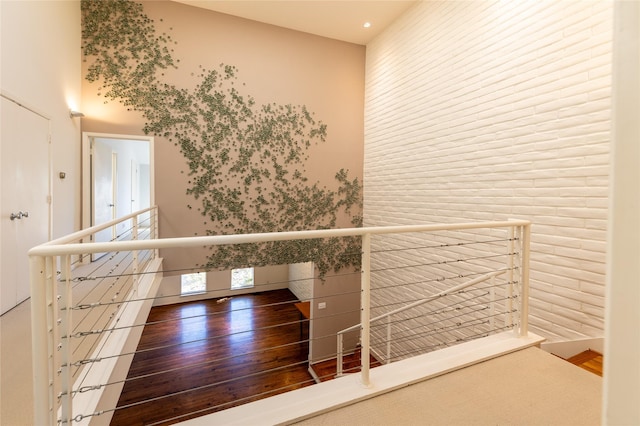 hallway with wood finished floors and an upstairs landing