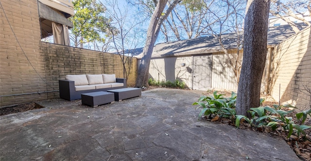 view of patio / terrace featuring an outdoor hangout area, an outdoor structure, and a fenced backyard