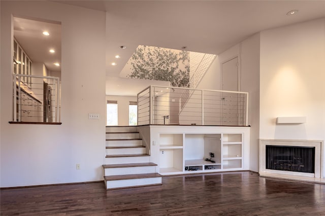 unfurnished living room with a fireplace, stairway, wood finished floors, and recessed lighting