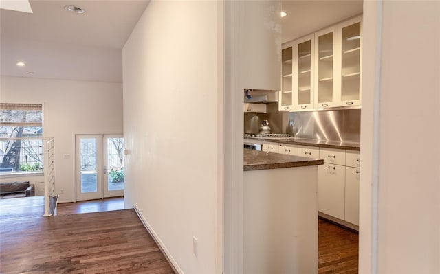 corridor with dark wood-style floors, baseboards, and recessed lighting