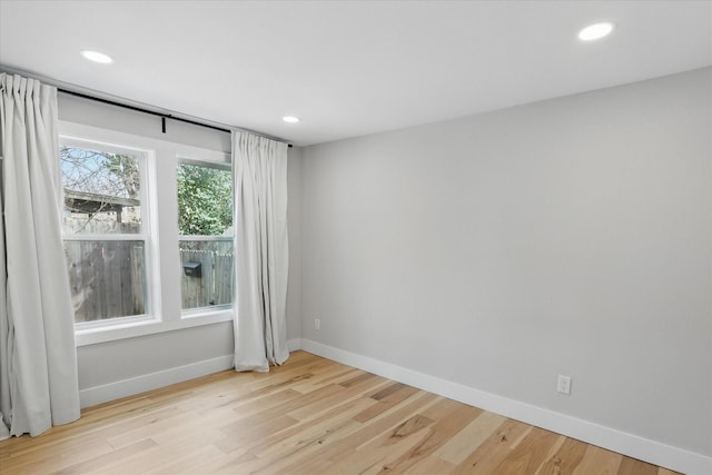 empty room with recessed lighting, baseboards, and light wood-style floors