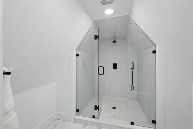 bathroom featuring visible vents, baseboards, a shower stall, vaulted ceiling, and marble finish floor