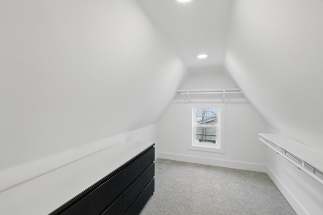 spacious closet with light carpet and vaulted ceiling