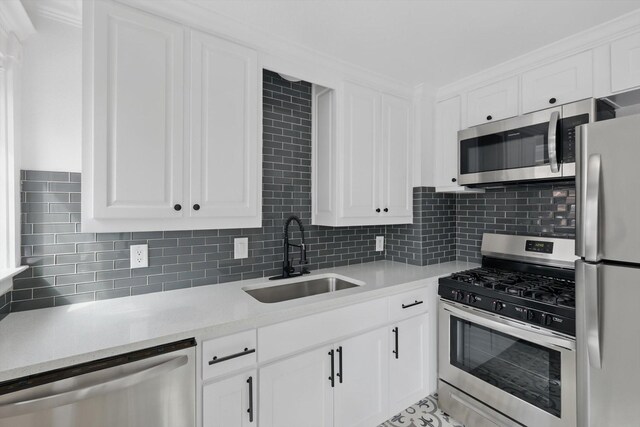 kitchen featuring a sink, appliances with stainless steel finishes, white cabinets, and light countertops