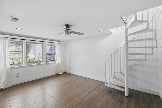 interior space featuring visible vents, baseboards, wood finished floors, and stairway