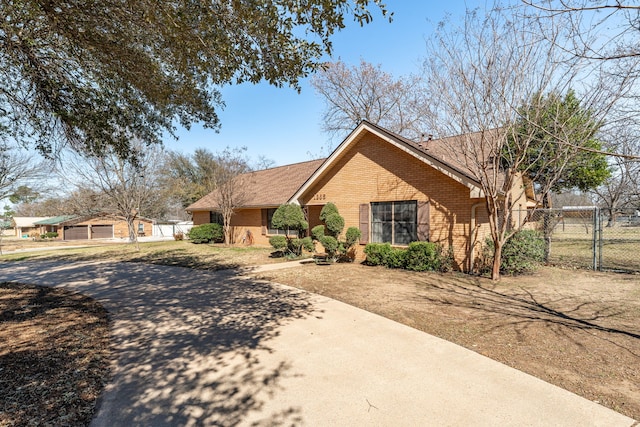 ranch-style house featuring a gate, brick siding, and fence