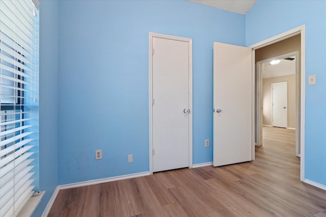 unfurnished bedroom with wood finished floors and baseboards