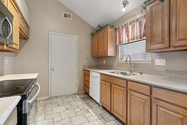 kitchen with visible vents, lofted ceiling, appliances with stainless steel finishes, light countertops, and a sink