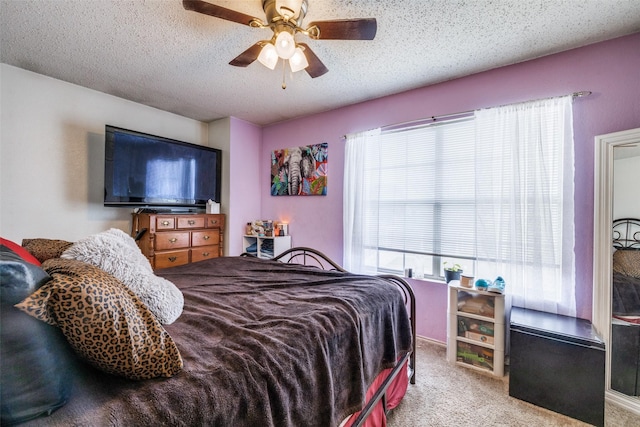 carpeted bedroom with a ceiling fan and a textured ceiling