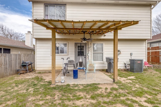 back of property with a yard, central AC unit, a ceiling fan, a patio area, and fence