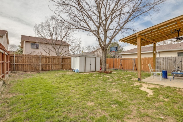 view of yard with an outbuilding, a fenced backyard, a patio, and a storage unit