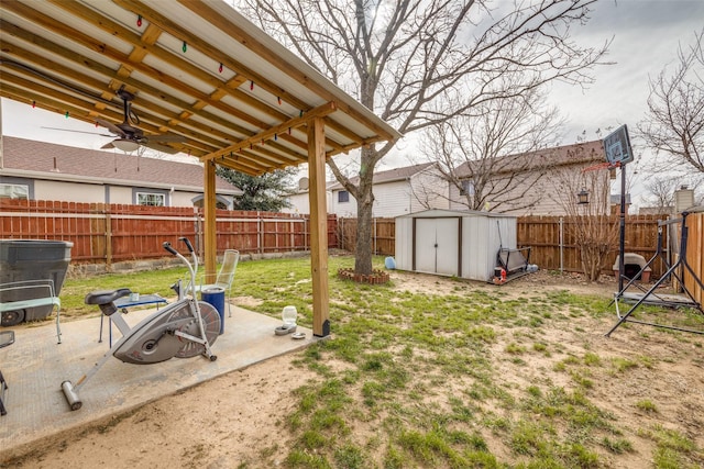 view of yard featuring a shed, a fenced backyard, a patio, and an outbuilding