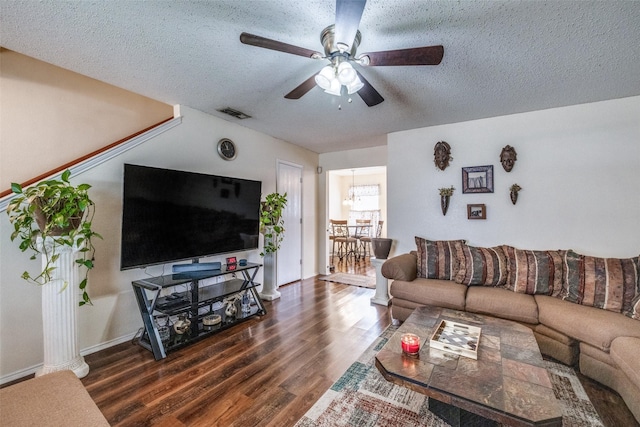 living area featuring visible vents, a textured ceiling, a ceiling fan, and dark wood-style flooring