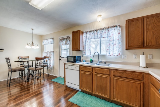 kitchen featuring dark wood-style floors, brown cabinetry, white dishwasher, a sink, and black microwave