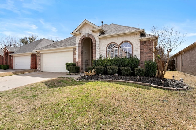 view of front facade with concrete driveway, roof with shingles, an attached garage, a front lawn, and brick siding