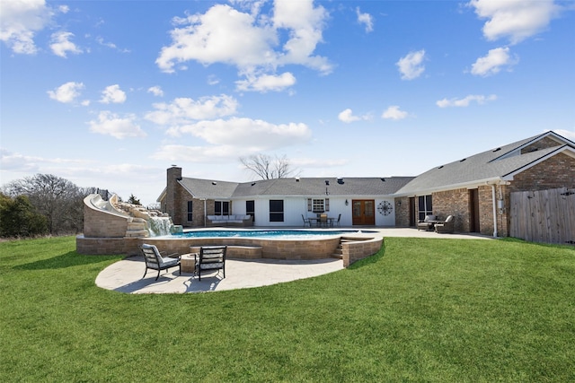 back of house featuring a patio, an outdoor pool, and brick siding
