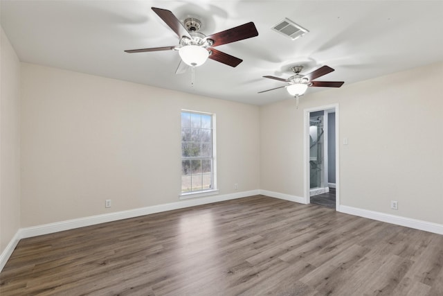 empty room featuring visible vents, baseboards, ceiling fan, and wood finished floors