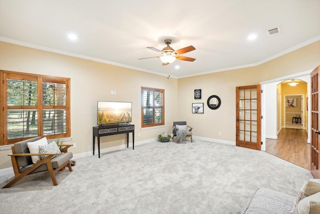 living area with carpet floors, arched walkways, french doors, visible vents, and baseboards