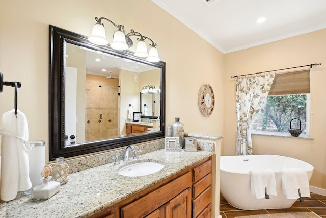 bathroom with vanity, baseboards, a freestanding bath, a stall shower, and crown molding