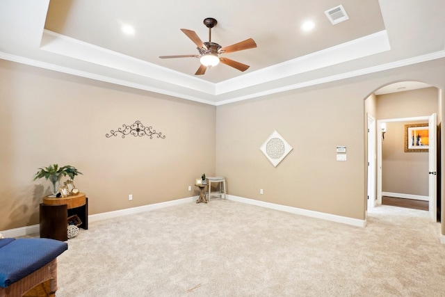 interior space featuring arched walkways, a raised ceiling, visible vents, and light colored carpet