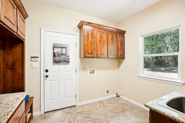 clothes washing area featuring electric dryer hookup, hookup for a washing machine, cabinet space, and baseboards