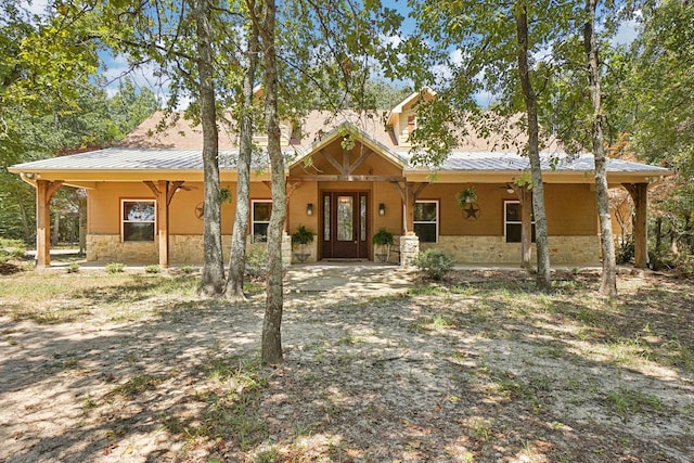 view of front of home with stone siding and metal roof