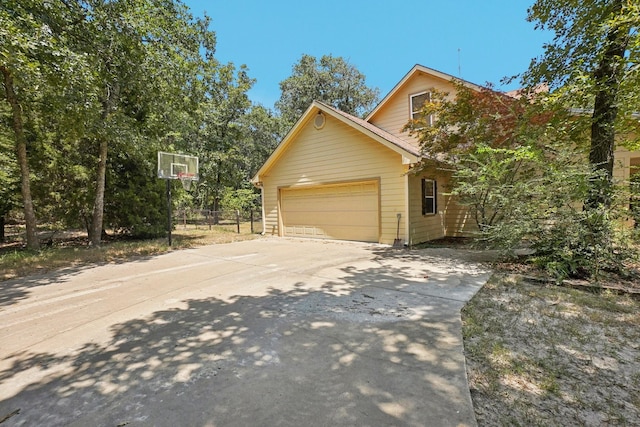 view of property exterior featuring a garage and concrete driveway