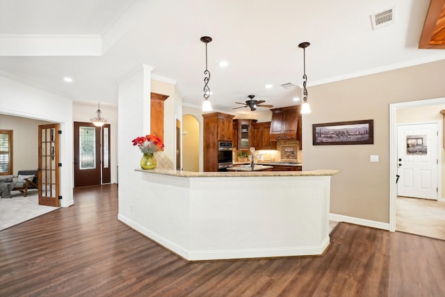 kitchen with arched walkways, dark wood-style flooring, visible vents, stainless steel oven, and a peninsula