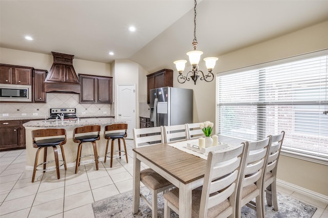 dining space with recessed lighting, a chandelier, light tile patterned flooring, and vaulted ceiling