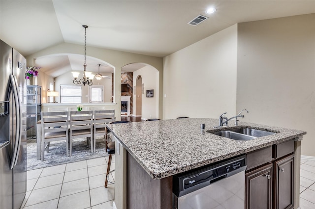 kitchen featuring visible vents, a sink, appliances with stainless steel finishes, lofted ceiling, and dark brown cabinets