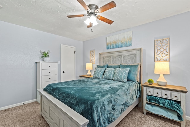 bedroom featuring baseboards, carpet floors, a textured ceiling, and a ceiling fan