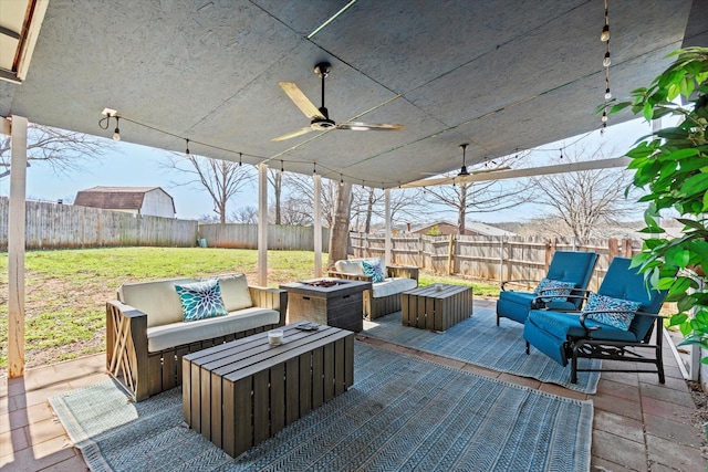 view of patio featuring an outdoor living space with a fire pit, a fenced backyard, and ceiling fan