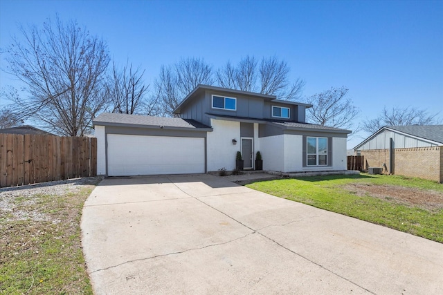 view of front facade featuring a garage, concrete driveway, a front yard, and fence