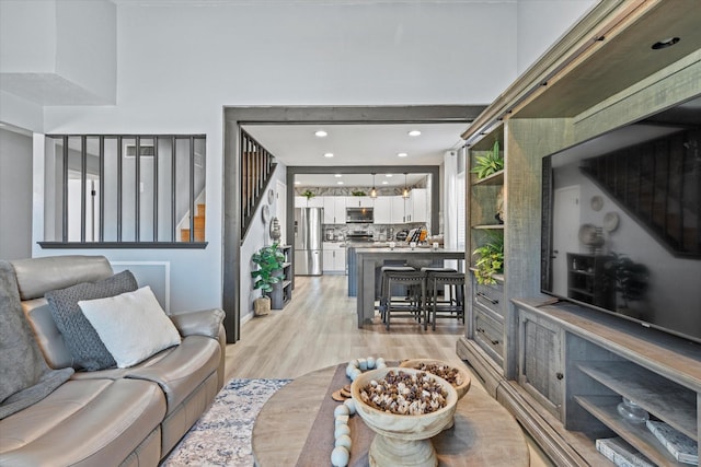 living room featuring stairway, recessed lighting, and light wood-style flooring