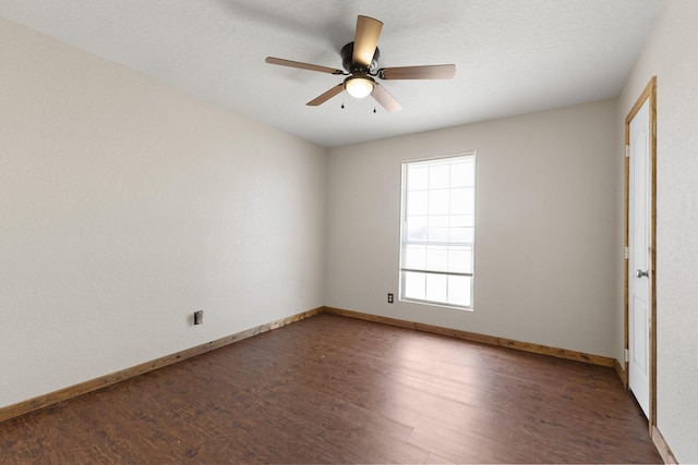 empty room with ceiling fan, wood finished floors, and baseboards