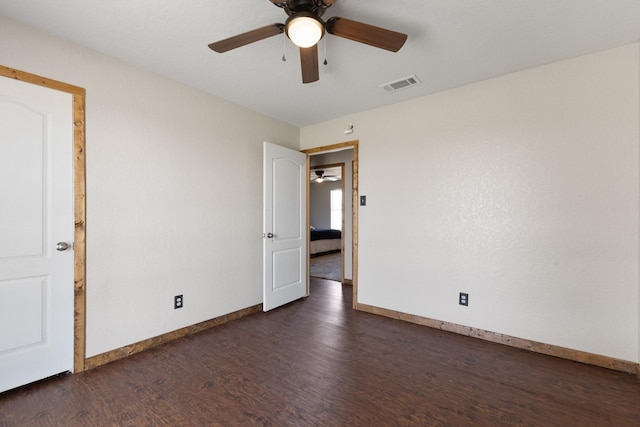 empty room with a ceiling fan, baseboards, visible vents, and wood finished floors