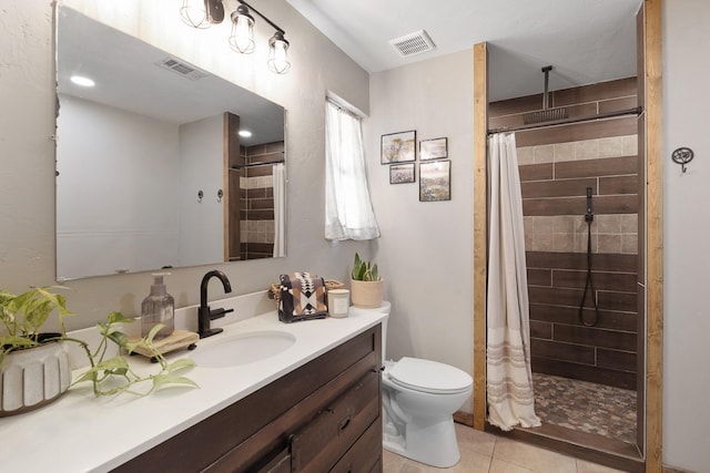 full bath featuring a tile shower, tile patterned flooring, vanity, and visible vents