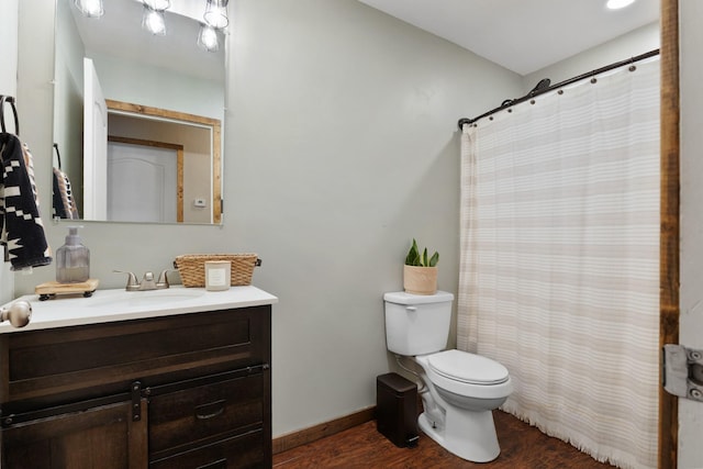 full bathroom with toilet, a shower with shower curtain, wood finished floors, vanity, and baseboards