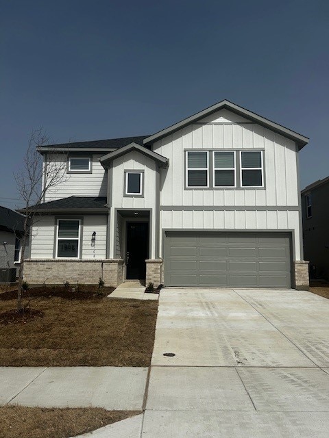 view of front of house featuring a garage, central AC, board and batten siding, and concrete driveway