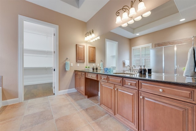 bathroom with tile patterned flooring, a sink, a spacious closet, a shower stall, and double vanity