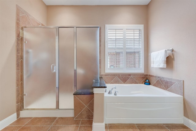 bathroom with tile patterned flooring, a garden tub, and a shower stall